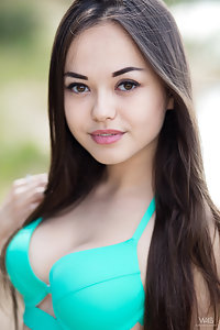 Sexy brunette Li Moon pulls off her green bikini