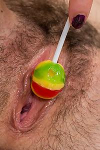Hairy brunette teen plays with a lollipop