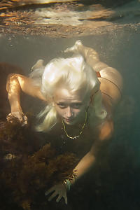 Blue-eyed blonde with pale skin swimming in the sea