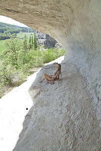 Cute teen spreads her pussy by a cliff