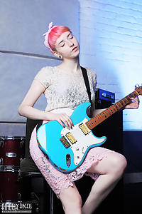 Pink-haired guitar player with pale skin spreading