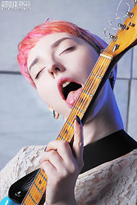 Pink-haired guitar player with pale skin spreading