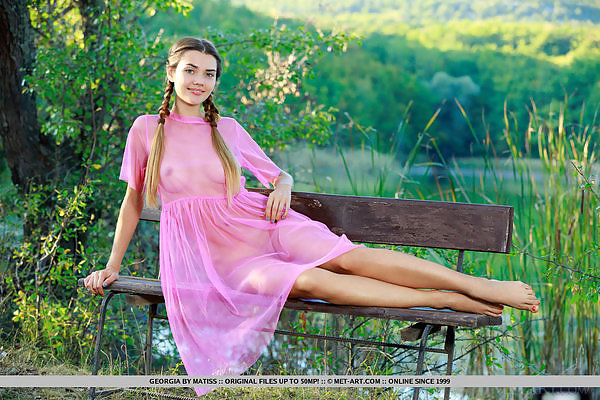 Lovely teen in a see-through dress by a bench