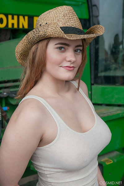 Busty redhead farm girl stripping by a tractor