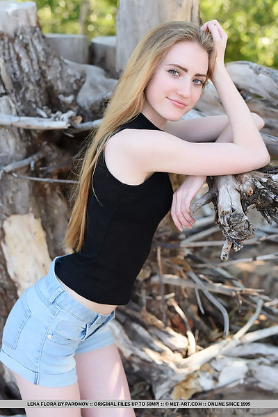 Blue-eyed blonde teen takes off her jean shorts outdoors