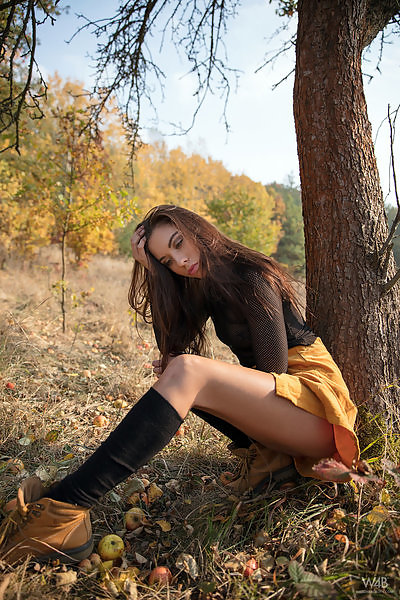 Sexy brunette in a short skirt spreads her holes in a forest