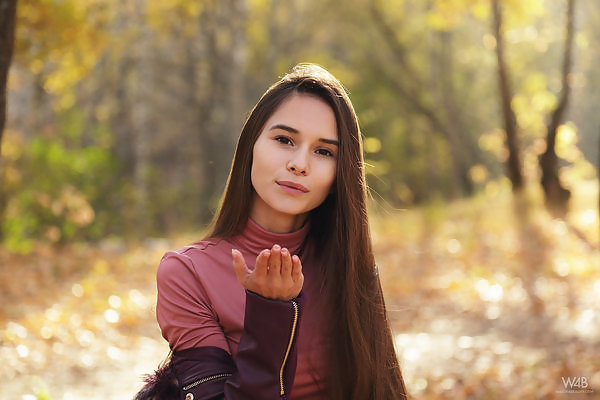 Long-haired brunette teen in posing in a forest