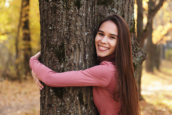 Long-haired brunette teen in posing in a forest