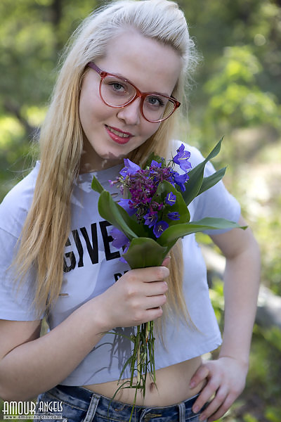 Blonde with glasses takes off her jean shorts in a forest