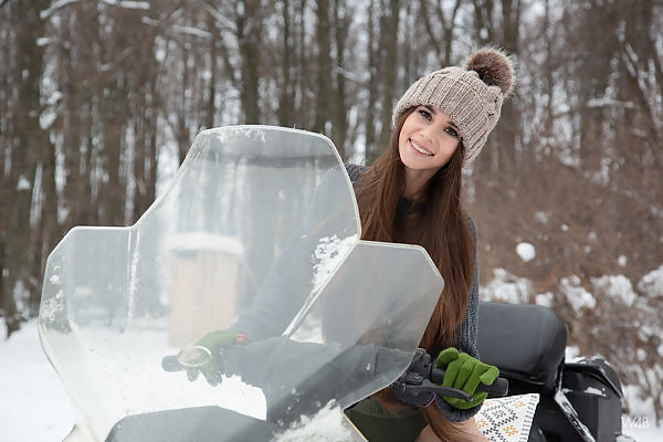Brunette teen with long hair pulls her panties aside in the snow