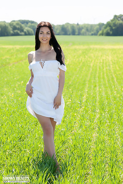 Black-haired babe nude in a field