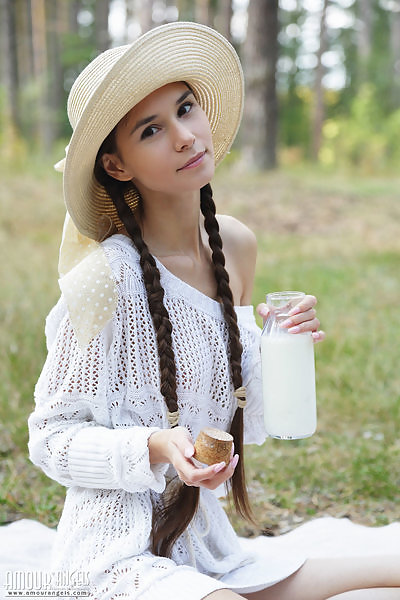 Cute brunette teen Leona Mia spreading in a field
