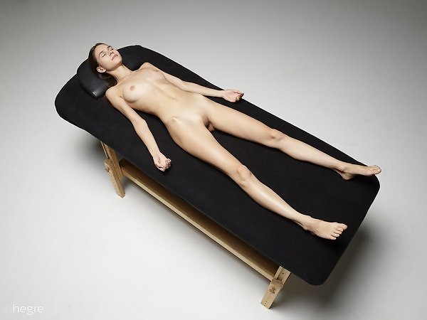 Skinny brunette teen masturbating on a massage table