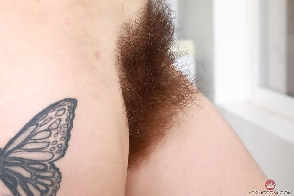 Tattooed redhead amateur reveals her thick hairy bush through her beaded thong