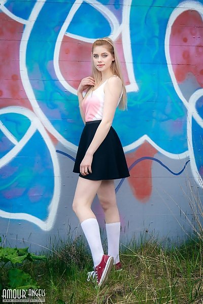 Blue-eyed blonde with pale skin lifts up her skirt