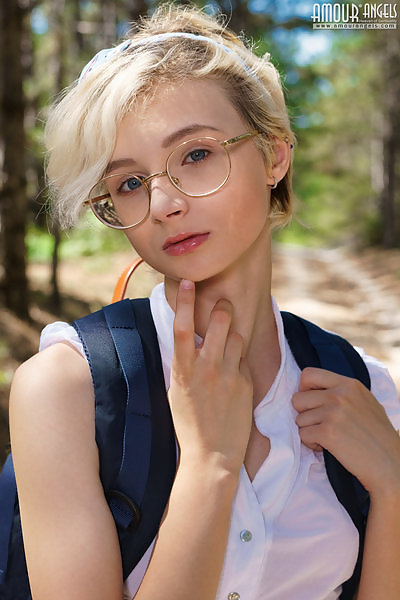 Cute blonde schoolgirl spreads her huge pussy lips in a forest
