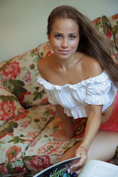 Brunette with blue eyes spreads her legs on a couch
