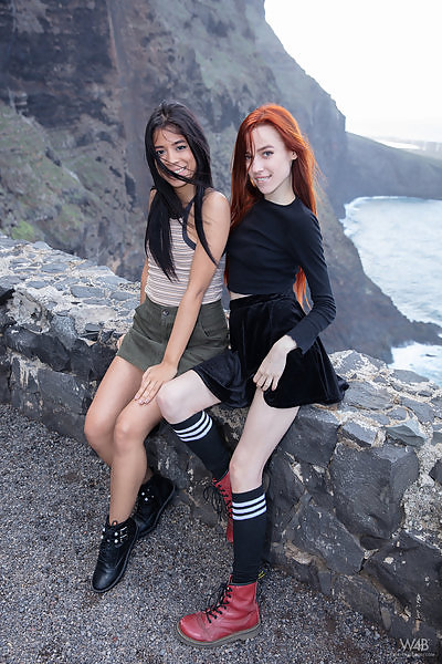 2 non-nude models lift up their skirts by the sea