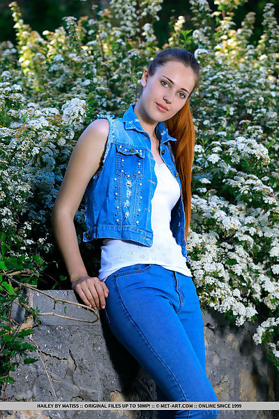 Teen with blue eyes takes off her jean outdoors