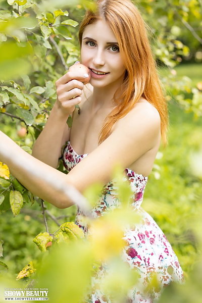 Redhead takes off her dress in a field