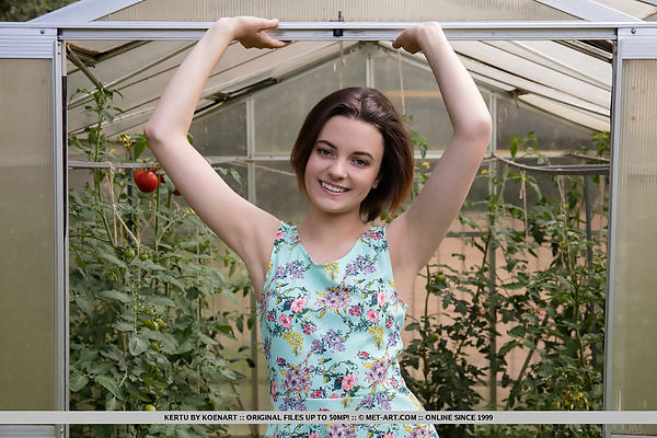Petite brunette teen posing nude in a greenhouse