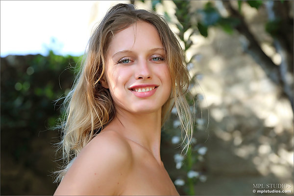 Flat-chested blonde with blue eyes nude in her backyard