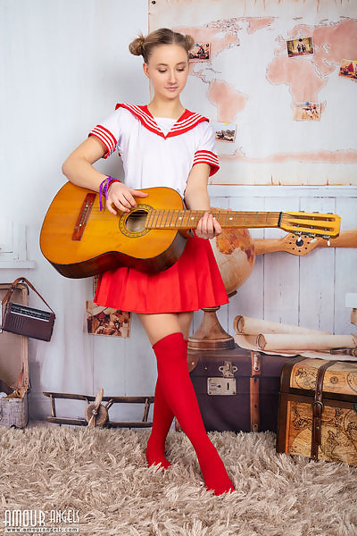 Cute blonde schoolgirl nude with a guitar