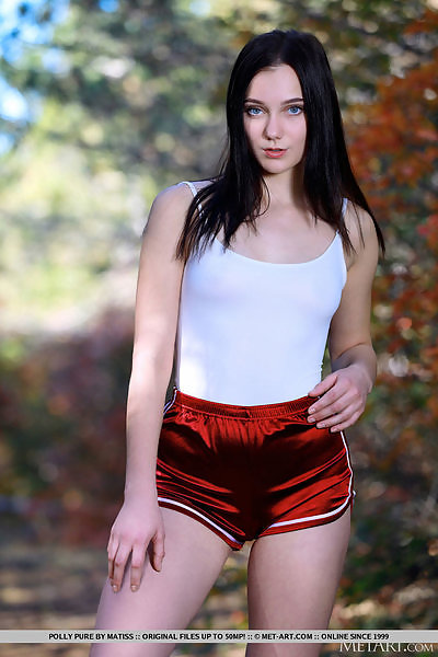 Black-haired teen with blue eyes stripping in a forest