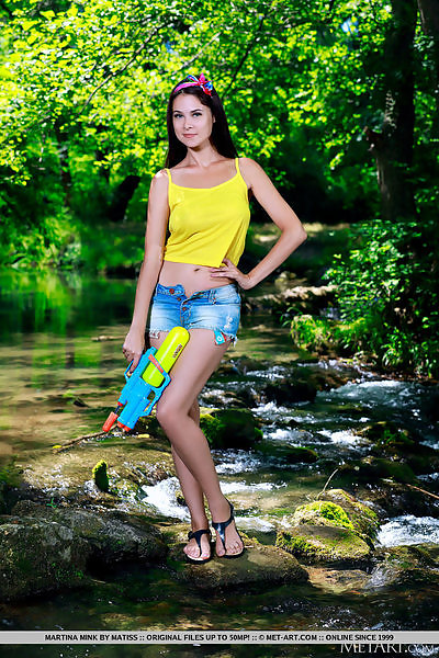 Busty brunette takes off her jean shorts by a river