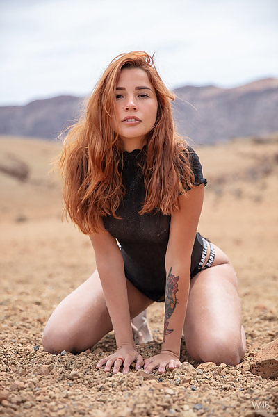 Sexy redhead Latina takes off her see-through top on a mountain