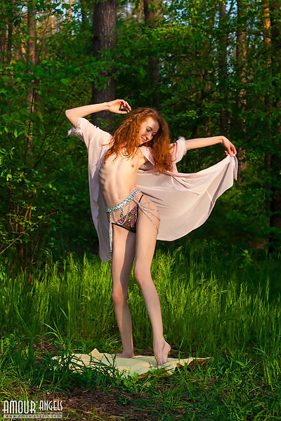 Skinny redhead nude in a field