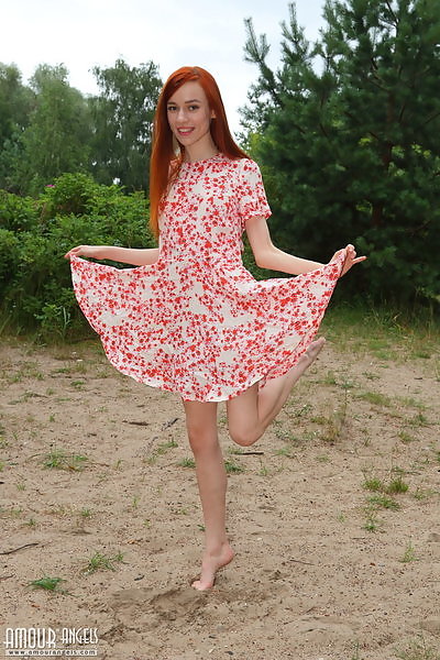 Sexy redhead lifts up her dress outdoors
