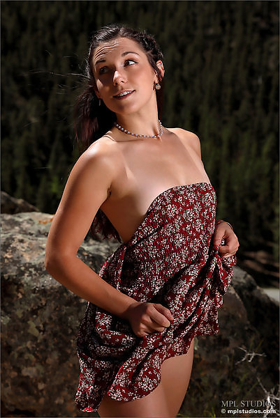 Sexy brunette lifts up her dress on a mountain
