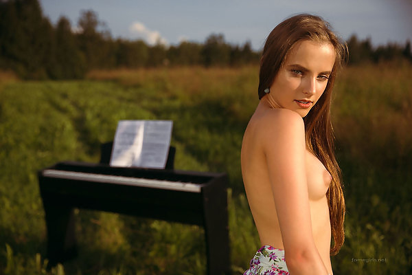 Cute girl with puffy nipples lifts up her dress in a field