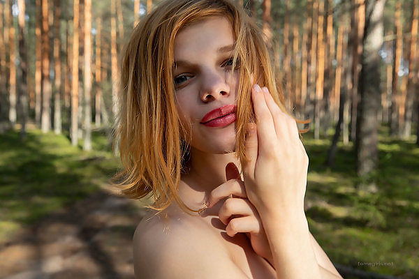 Cute shaved redhead nude in a forest