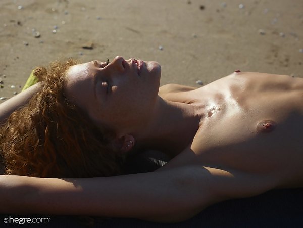 Freckled redhead shows off her ginger bush on a nudist beach
