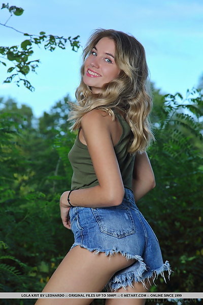 Flat-chested blonde cutie with blue eyes takes off her jean shorts outdoors