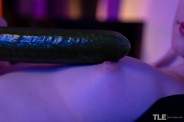 Pale cutie toying with a cucumber