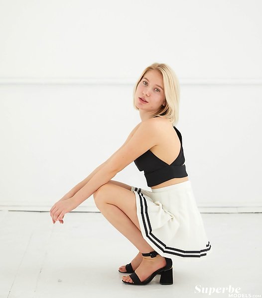 Natural blonde with green eyes lifts up her skirt
