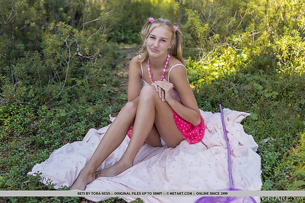 Cute blonde lifts up her pink skirt in a forest