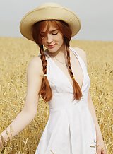 Redhead with pale skin spreading in a field