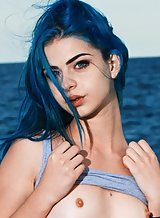 Flat-chested teen with blue hair stripping by the sea