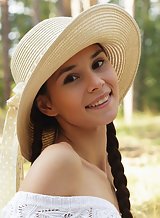 Cute brunette teen Leona Mia spreading in a field