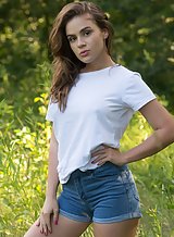 Brunette with firm boobs takes off her jean shorts outdoors