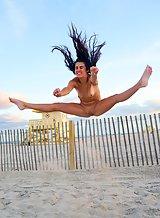 Cute brunette takes off her bikini at the beach