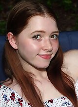 Freckled redhead teen toying in the backyard