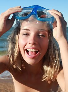 Cute blonde diver takes off her bikini at the beach