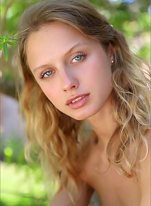 Flat-chested blonde with blue eyes posing nude