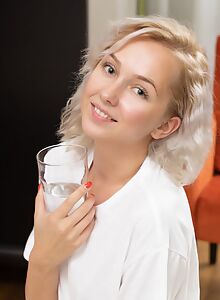 Cute blonde pours water all over her t-shirt