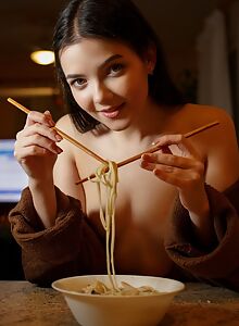 Cute curvy brunette eating noodles naked